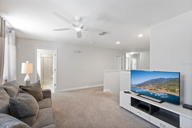 living area with visible vents, light carpet, and a textured ceiling