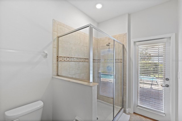 bathroom featuring a stall shower and toilet