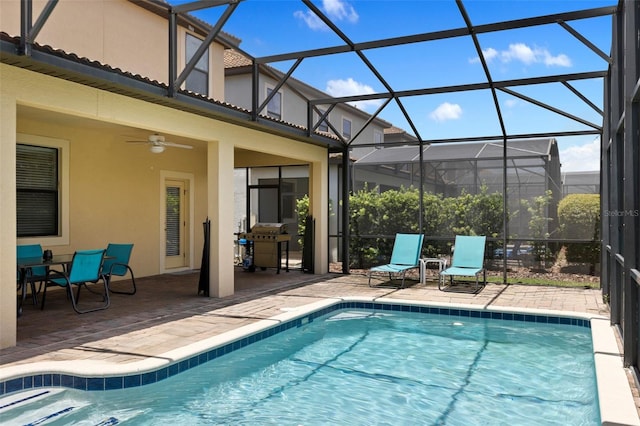 pool with a ceiling fan, glass enclosure, a patio area, and a grill