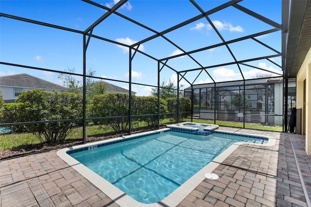 view of pool featuring glass enclosure, a pool with connected hot tub, and a patio