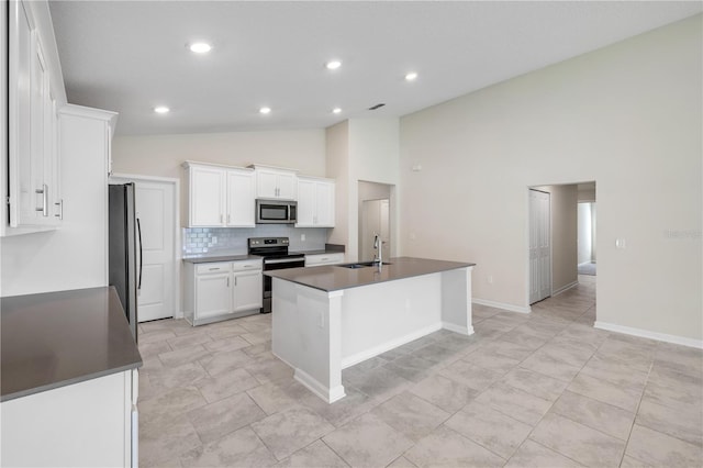 kitchen featuring dark countertops, appliances with stainless steel finishes, white cabinets, and a sink