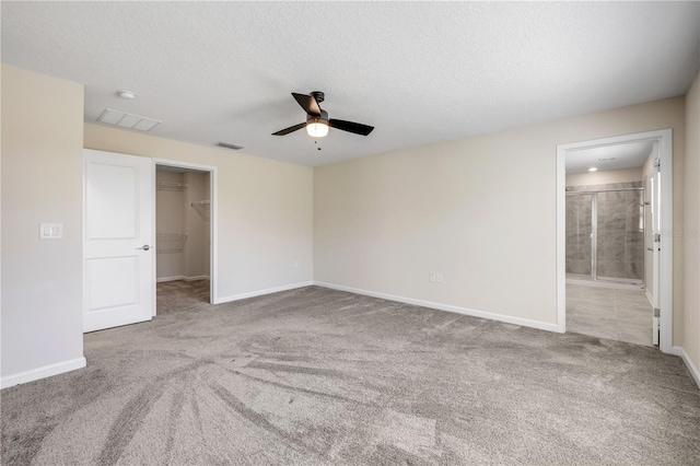 spare room with carpet floors, visible vents, a ceiling fan, a textured ceiling, and baseboards