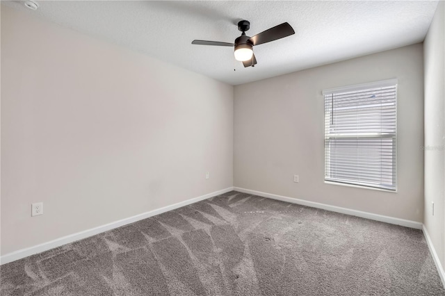 carpeted spare room with ceiling fan, a textured ceiling, and baseboards