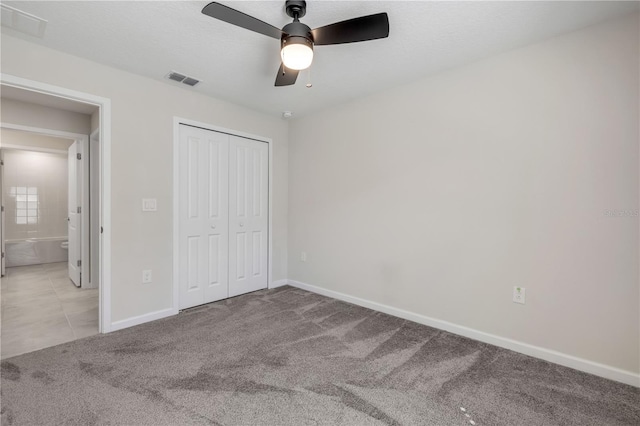 unfurnished bedroom featuring ceiling fan, carpet floors, visible vents, baseboards, and a closet