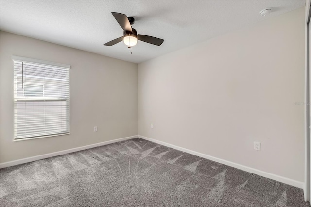 spare room featuring carpet floors, ceiling fan, baseboards, and a textured ceiling