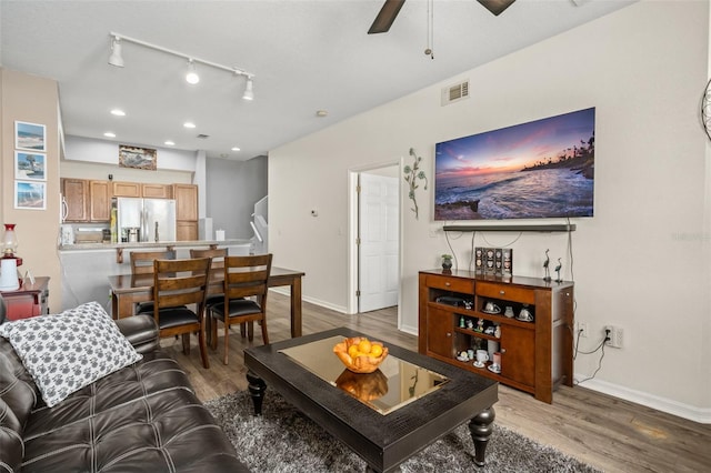 living area featuring wood finished floors, visible vents, and baseboards