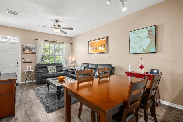 dining room with ceiling fan, wood finished floors, visible vents, and baseboards