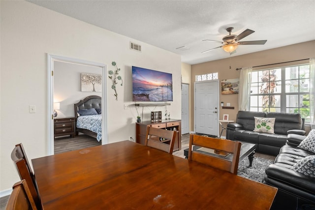 dining room with a ceiling fan, visible vents, and a textured ceiling