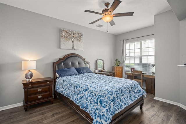 bedroom featuring a ceiling fan, visible vents, baseboards, and wood finished floors