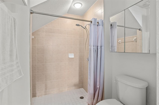 full bath with a shower stall, toilet, and a textured ceiling