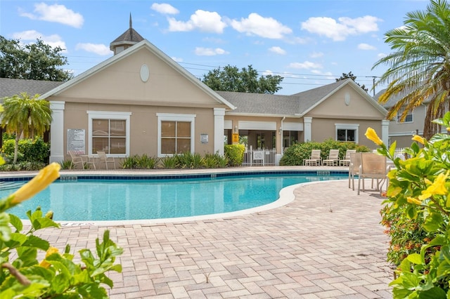 community pool featuring a patio and fence