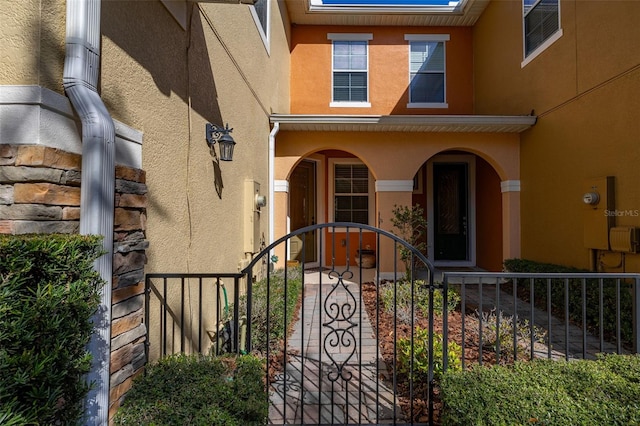 entrance to property with fence and stucco siding