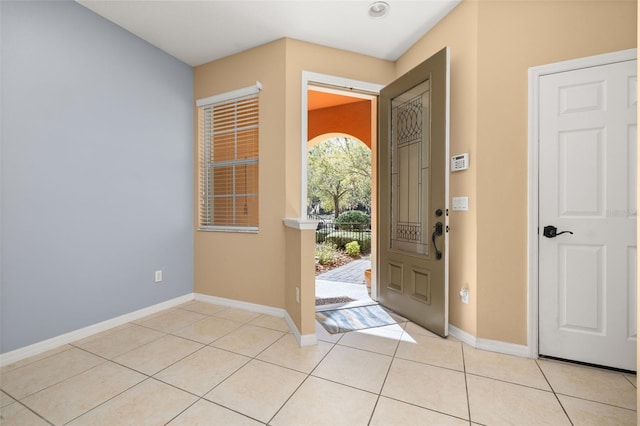 foyer featuring light tile patterned floors and baseboards