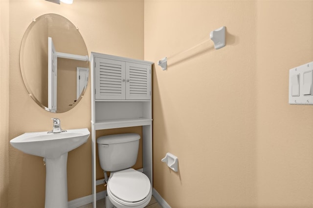 bathroom featuring toilet and baseboards