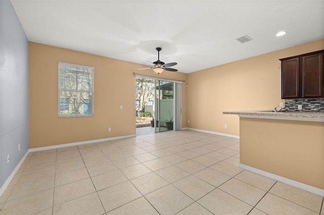 interior space with visible vents, ceiling fan, baseboards, and light tile patterned flooring