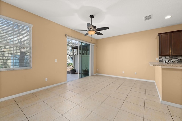 unfurnished room with light tile patterned floors, baseboards, visible vents, and ceiling fan