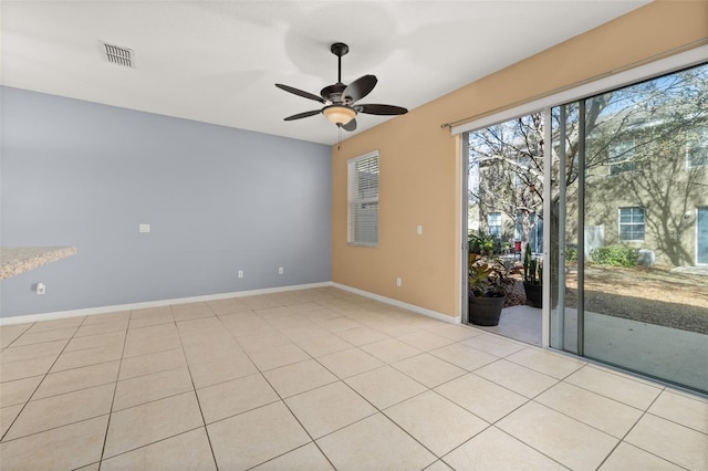 unfurnished room featuring ceiling fan, light tile patterned flooring, visible vents, and baseboards