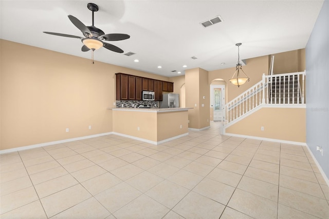 interior space with tasteful backsplash, visible vents, arched walkways, appliances with stainless steel finishes, and light countertops