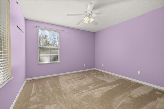 spare room with ceiling fan, a textured ceiling, baseboards, and carpet flooring