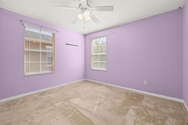 spare room featuring carpet flooring, ceiling fan, a textured ceiling, and baseboards