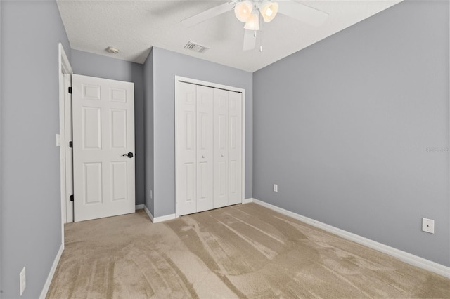 unfurnished bedroom with baseboards, visible vents, ceiling fan, carpet floors, and a closet