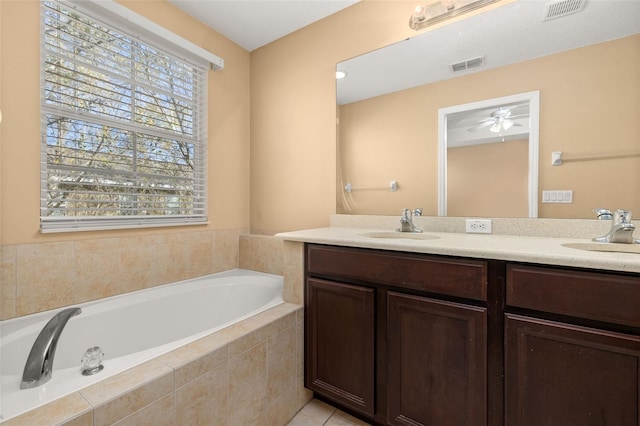 bathroom featuring double vanity, a garden tub, visible vents, and a sink