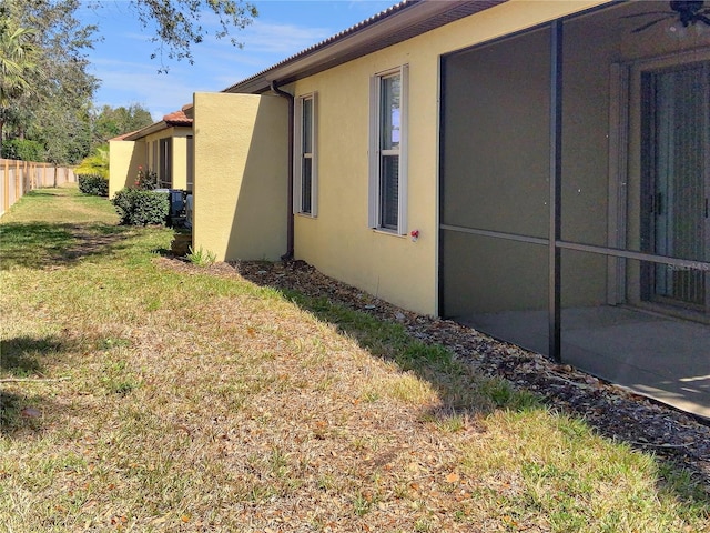 view of home's exterior featuring a yard, fence, and stucco siding