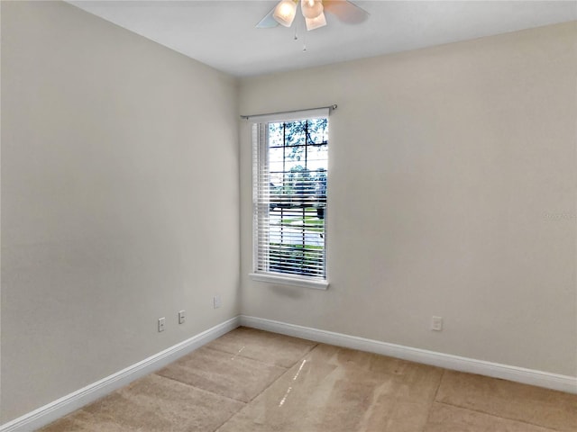 empty room with a ceiling fan and baseboards