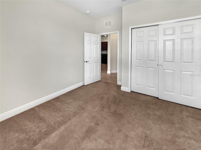 unfurnished bedroom featuring carpet, visible vents, baseboards, and a closet