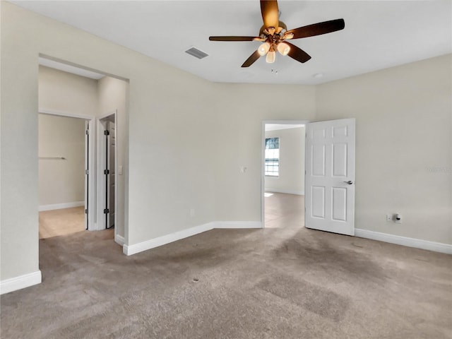 unfurnished room featuring ceiling fan, carpet floors, visible vents, and baseboards