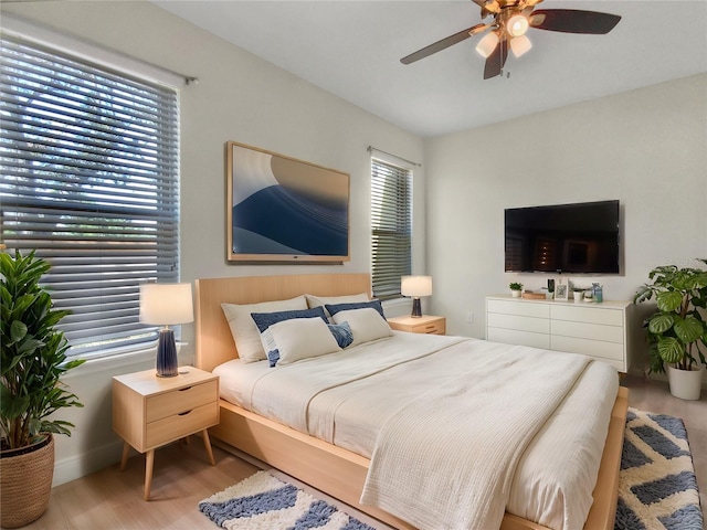 bedroom with ceiling fan, baseboards, and wood finished floors