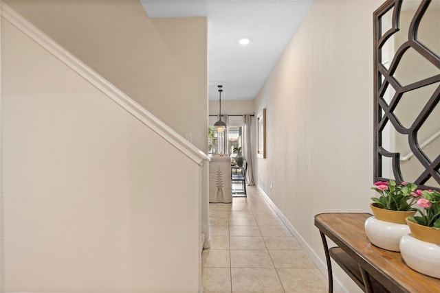 corridor featuring light tile patterned floors, baseboards, and recessed lighting