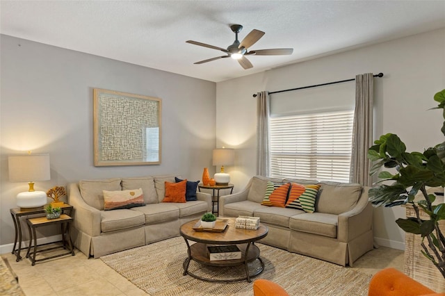 living area with a ceiling fan and baseboards