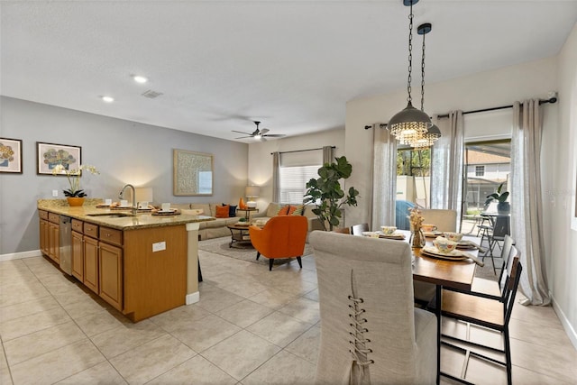 kitchen with a sink, baseboards, brown cabinets, dishwasher, and pendant lighting