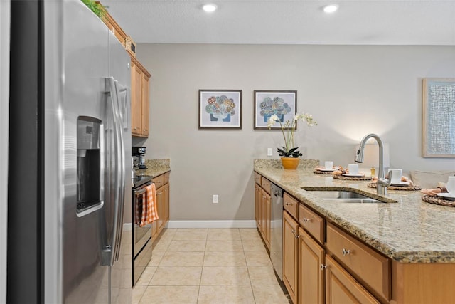 kitchen with light tile patterned floors, baseboards, a peninsula, stainless steel appliances, and a sink