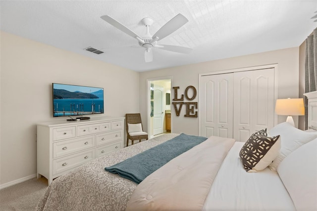 bedroom with ceiling fan, carpet flooring, visible vents, baseboards, and a closet