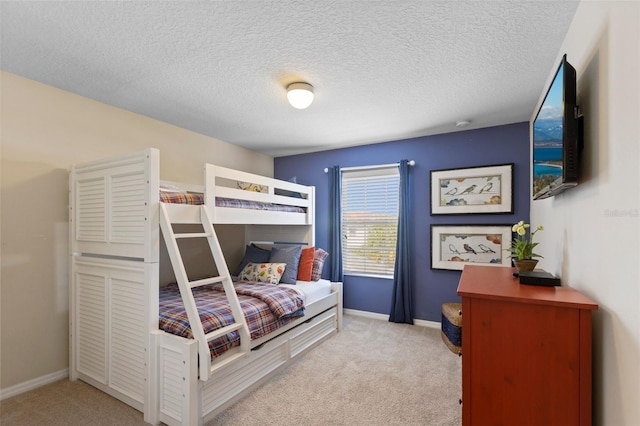 bedroom with a textured ceiling, carpet floors, and baseboards