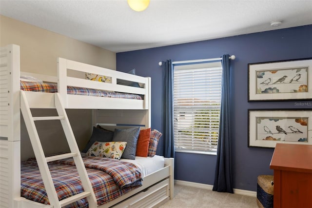 bedroom with a textured ceiling, carpet floors, and baseboards