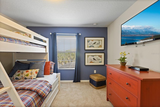 bedroom featuring light carpet, baseboards, and a textured ceiling