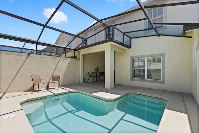 pool with glass enclosure and a patio area