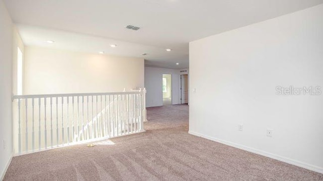 unfurnished room featuring carpet floors, visible vents, baseboards, and recessed lighting