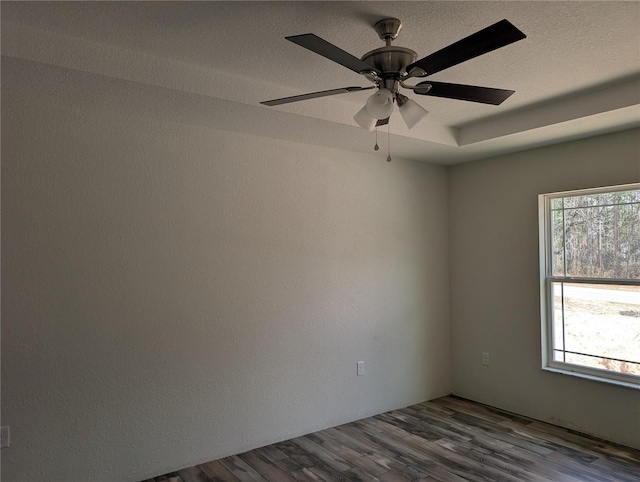 unfurnished room with a healthy amount of sunlight, a textured ceiling, and wood finished floors