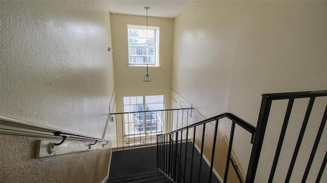 stairway featuring a textured wall
