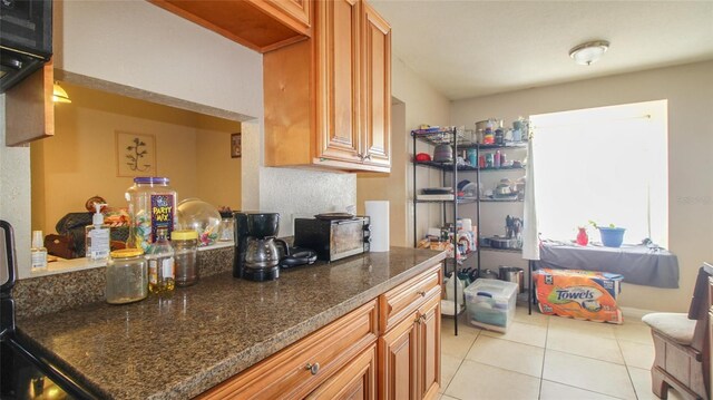 kitchen featuring light tile patterned flooring and brown cabinetry