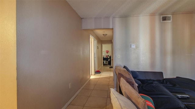 corridor featuring light tile patterned flooring, baseboards, and visible vents