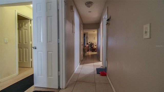hallway featuring light tile patterned floors and baseboards