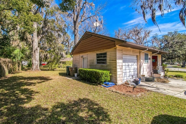 view of side of home featuring a lawn and concrete driveway