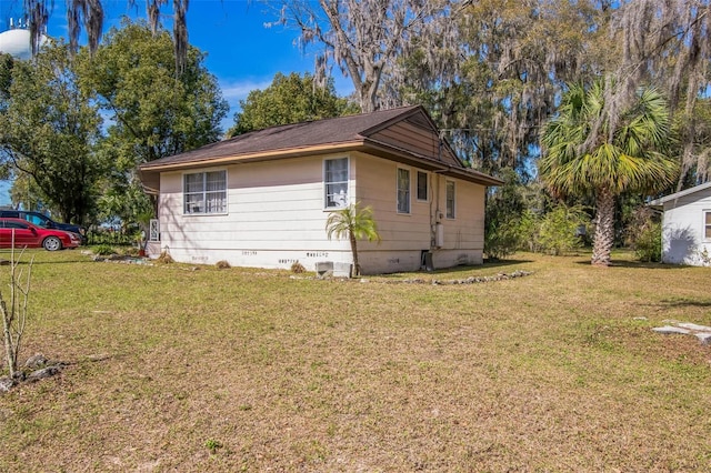 view of side of property featuring crawl space and a yard