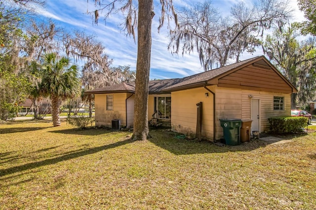 back of property with a yard and central air condition unit