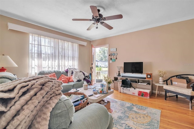 living area featuring ornamental molding, ceiling fan, baseboards, and wood finished floors